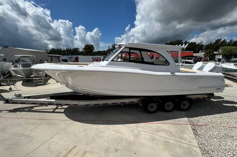 Slide: The Image of 2026 Southport 33 DC boat on trailer under cloudy sky at marina. - 3