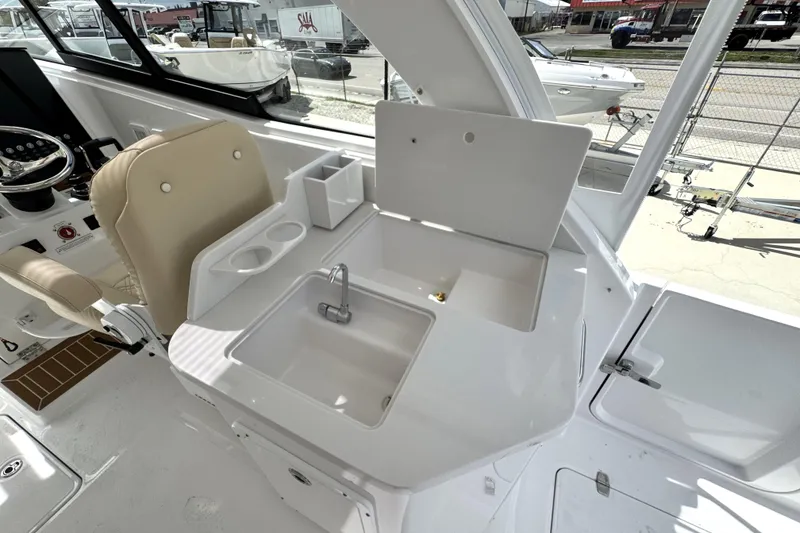 Slide: The Image of Interior of 2026 Southport 33 DC boat featuring a compact sink and seating area. - 30