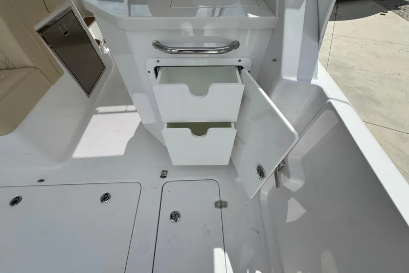 Slide: The Image of 2026 Southport 33 DC boat interior with open storage drawers and seating area. - 32