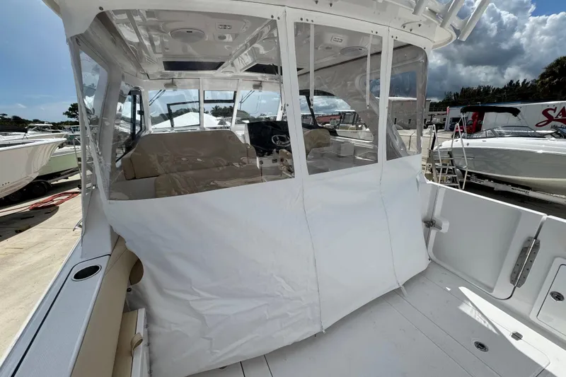 Slide: The Image of 2026 Southport 33 DC boat with covered cockpit, docked under a cloudy sky. - 40