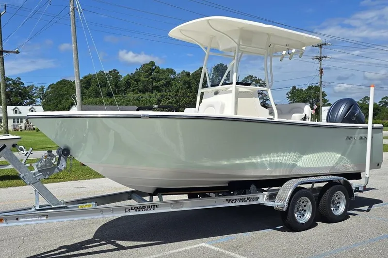 Slide: The Image of 2026 Sea Born LX21 Center Console boat on trailer, parked outdoors under clear sky. - 20