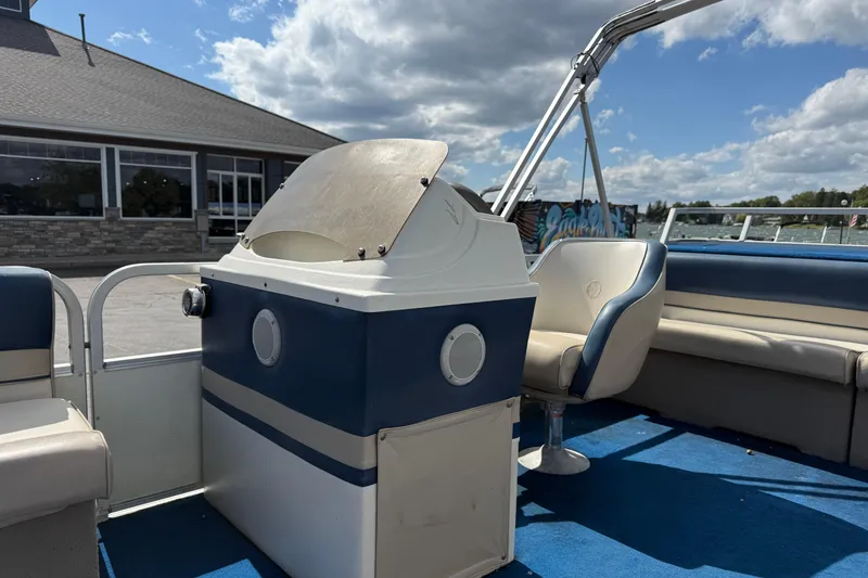 Slide: The Image of 1997 Crest 18 boat interior with blue and white seating, steering console, and clear sky background. - 11