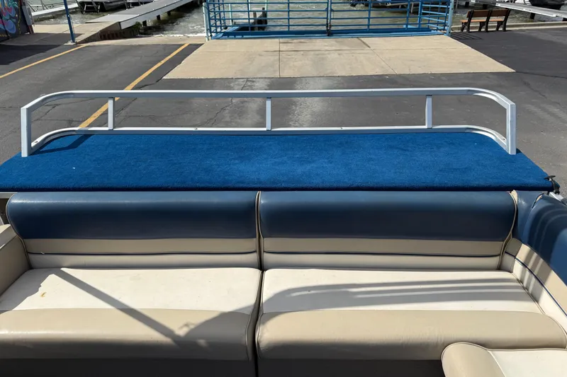 Slide: The Image of Pontoon boat interior with blue carpet and beige seating, dockside view. Crest 18, 1997 model. - 12