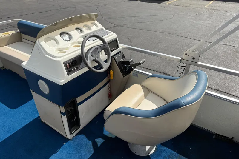 Slide: The Image of 1997 Crest 18 boat cockpit with steering wheel and blue-trimmed captain's chair. - 14