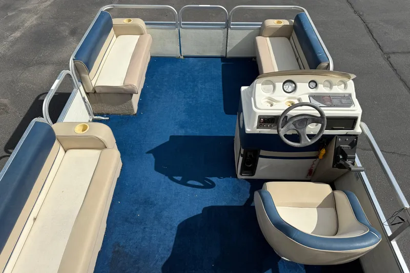 Slide: The Image of 1997 Crest 18 pontoon boat interior with blue carpet and beige seating. - 17