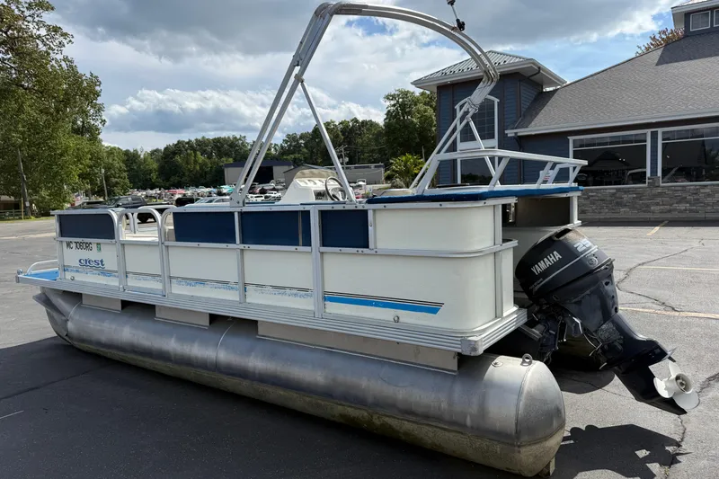 Slide: The Image of 1997 Crest 18 pontoon boat with Yamaha outboard motor, parked outdoors. - 6