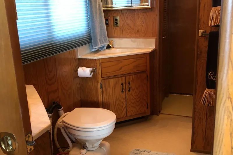 Slide: The Image of 1989 Sumerset 14x71 houseboat bathroom with wood paneling and compact fixtures. - 11