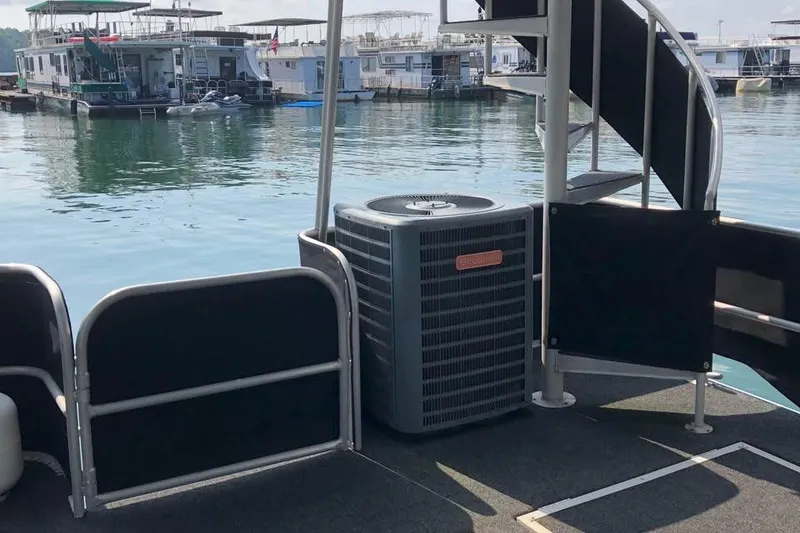 Slide: The Image of Houseboat docked with visible air conditioning unit and spiral staircase, Sumerset 14x71, 1989 model. - 13