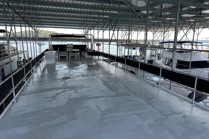 Slide: The Image of 1989 Sumerset 14x71 houseboat docked under covered marina with spacious deck. - 14