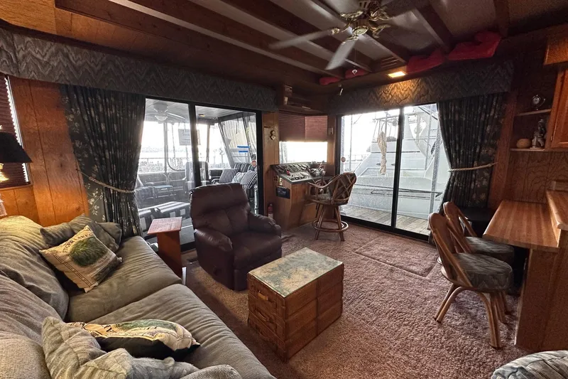 Slide: The Image of 1989 Sumerset 14x71 houseboat interior with cozy seating, wooden decor, and modern amenities. - 2