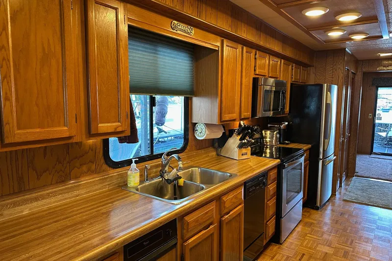 Slide: The Image of 1989 Sumerset 14x71 kitchen with stainless steel appliances and wooden cabinets. - 4