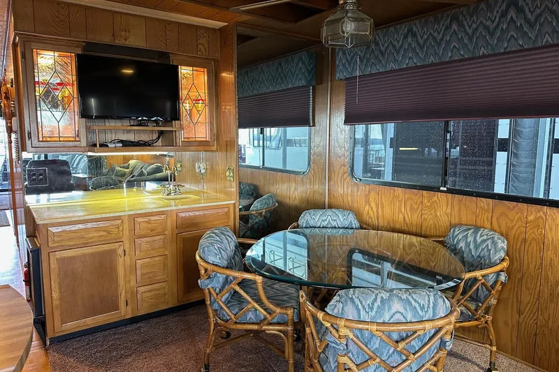 Slide: The Image of 1989 Sumerset 14x71 houseboat interior with wooden cabinets and ladder. - 5