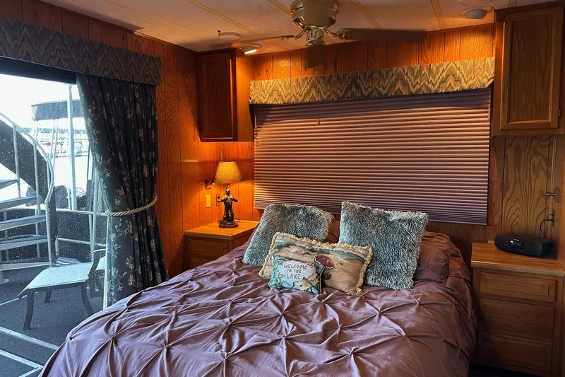 Slide: The Image of Cozy bedroom in 1989 Sumerset 14x71 houseboat with wood paneling and floral bedding. - 7