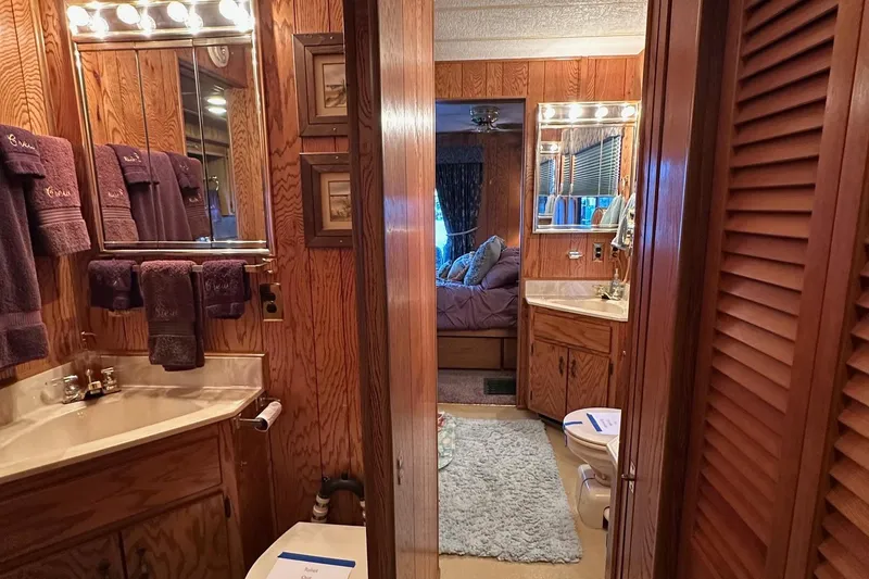 Slide: The Image of Cozy bedroom in 1989 Sumerset 14x71 houseboat with plush bedding and warm lighting. - 8