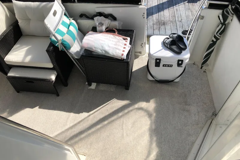 Slide: The Image of Cozy seating area on 2004 Carver 366 Motor Yacht with cooler and striped pillow. - 23