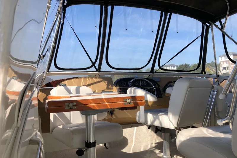 Slide: The Image of 2004 Carver 366 Motor Yacht interior with helm, seating, and wooden table. - 26