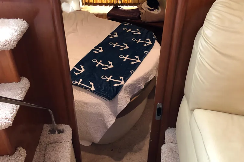 Slide: The Image of Interior of 2004 Carver 366 Motor Yacht with cozy bed and nautical-themed blanket. - 12