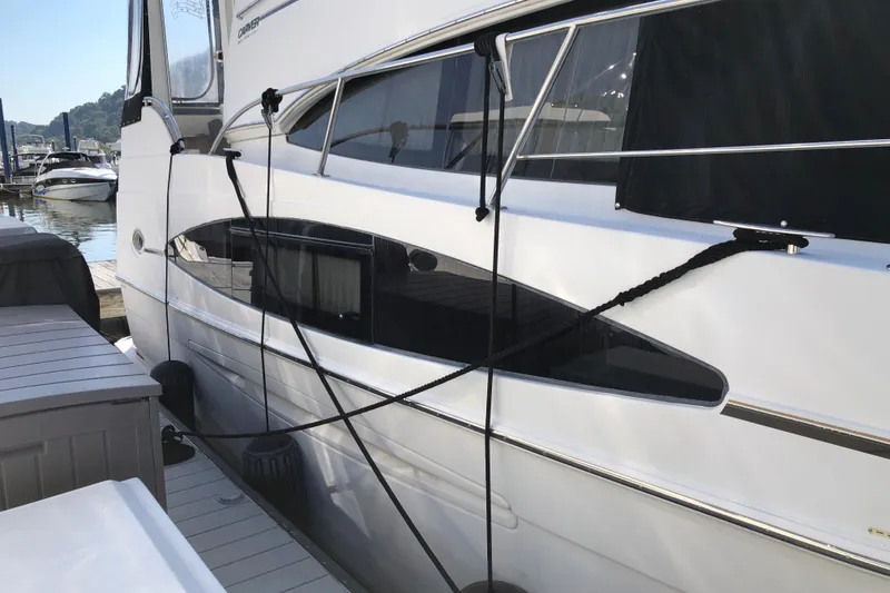 Slide: The Image of 2004 Carver 366 Motor Yacht docked at marina, side view with ropes and fenders. - 4