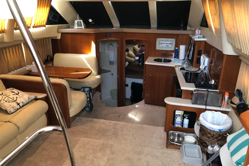 Slide: The Image of Interior of 2004 Carver 366 Motor Yacht with cozy seating and compact kitchen area. - 5
