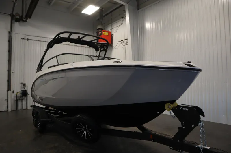Slide: The Image of 2026 Yamaha Boats AR250 in a showroom, sleek design on a trailer. - 2
