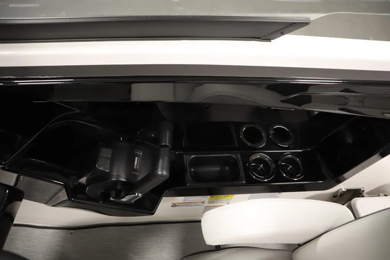 Slide: The Image of Interior of 2026 Yamaha AR250 boat with cup holders and sleek black design. - 27