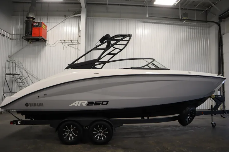 Slide: The Image of 2026 Yamaha Boats AR250 in a showroom, sleek design on a trailer. - 3