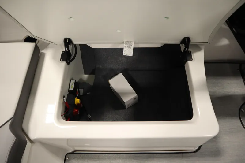 Slide: The Image of 2026 Yamaha AR250 boat storage compartment with open lid and visible accessories. - 35