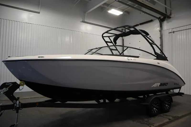 Slide: The Image of 2026 Yamaha Boats AR250 in a showroom, sleek design with a modern black and white finish. - 7
