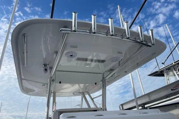 Slide: The Image of 2013 Bahama 41 Open Fisherman boat with rod holders and T-top under blue sky. - 11