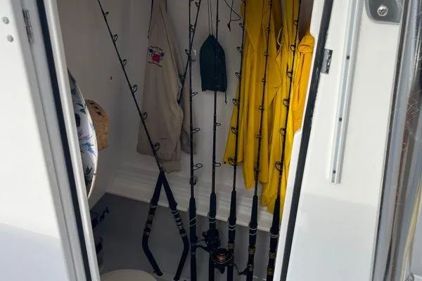 Slide: The Image of Storage area on a 2013 Bahama 41 Open Fisherman with fishing rods and rain gear. - 14