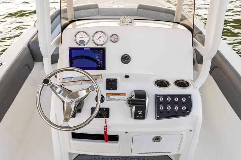 Slide: The Image of 2026 NauticStar 231 Hybrid boat dashboard with steering wheel and control panel. - 10