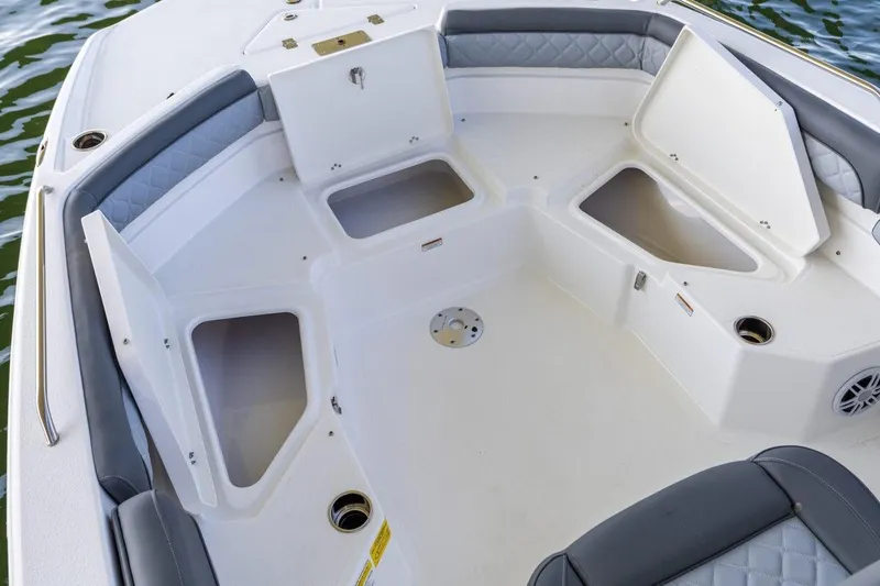 Slide: The Image of 2026 NauticStar 231 Hybrid boat interior with open storage compartments and cushioned seating. - 5