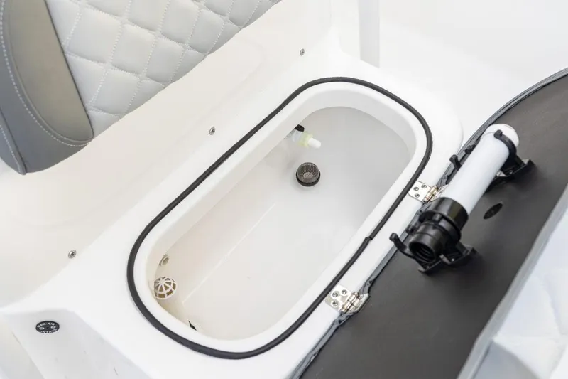 Slide: The Image of 2026 NauticStar 231 Hybrid boat storage compartment with cushioned seating and secure latch. - 6