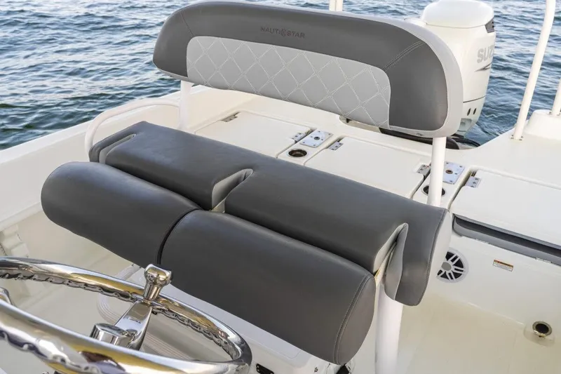 Slide: The Image of 2026 NauticStar 231 Hybrid boat interior with cushioned seating and steering wheel. - 9