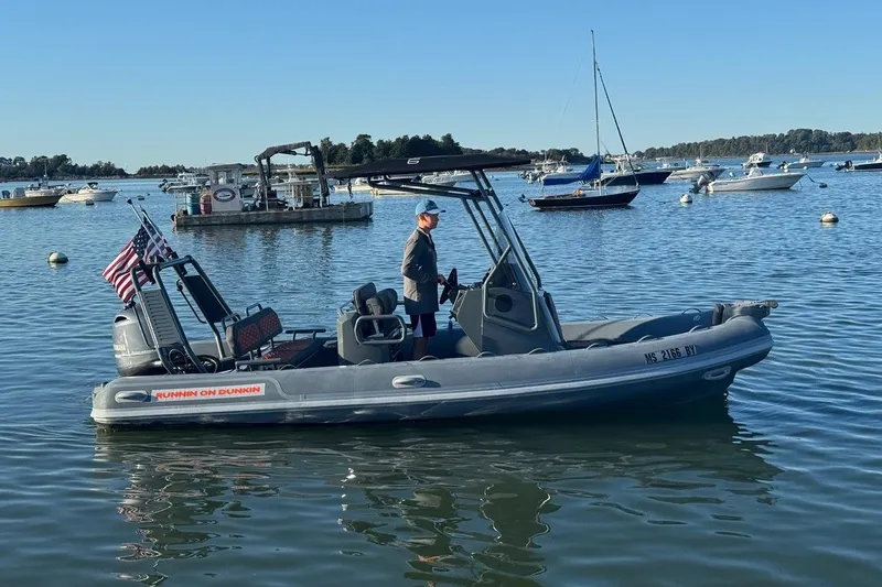 The Image of 2025 Highfield Sport 560 boat on calm water, American flag, sunny day. - 0