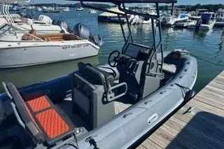 Slide: The Image of 2025 Highfield Sport 560 boat docked in marina, featuring American flag and outboard motor. - 5