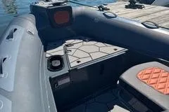 Slide: The Image of 2025 Highfield Sport 560 boat docked, featuring a powerful outboard motor and American flag. - 7