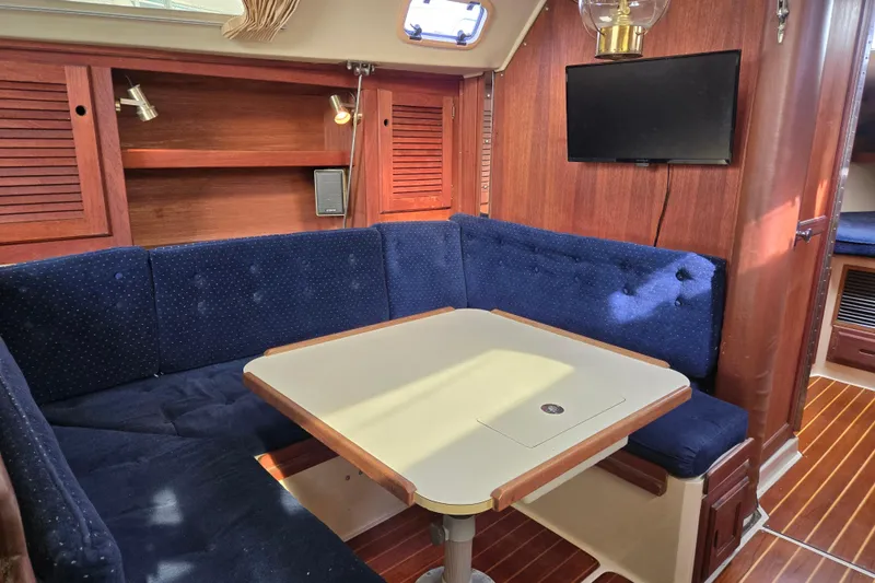 Slide: The Image of Interior of 1989 Catalina 36 sailboat with blue cushioned seating and wooden accents. - 12
