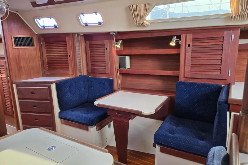Slide: The Image of Interior of 1989 Catalina 36 sailboat with wooden cabinetry and blue cushioned seating. - 13
