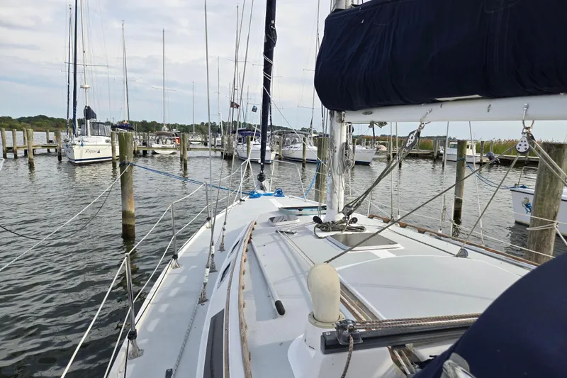 Slide: The Image of 1989 Catalina 36 sailboat docked at a marina, surrounded by other boats. - 2