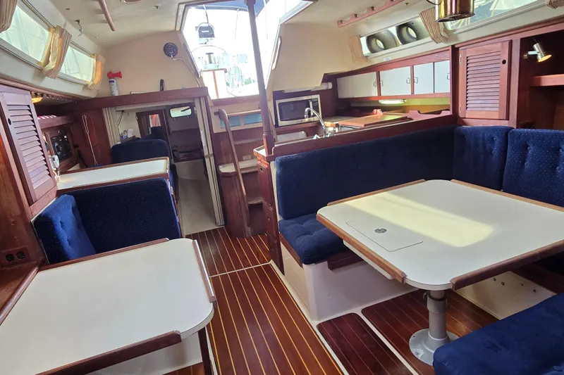 Slide: The Image of Interior of 1989 Catalina 36 sailboat with wood accents and blue seating. - 22