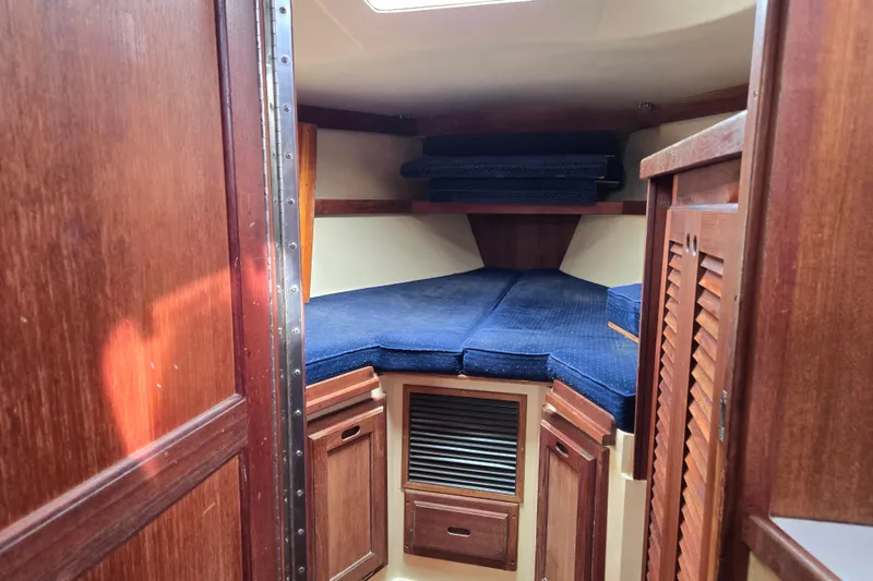Slide: The Image of 1989 Catalina 36 sailboat interior with blue cushions and wooden cabinetry. - 23