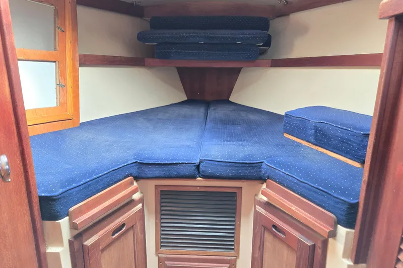 Slide: The Image of 1989 Catalina 36 sailboat cabin with blue cushions and wooden cabinetry. - 24