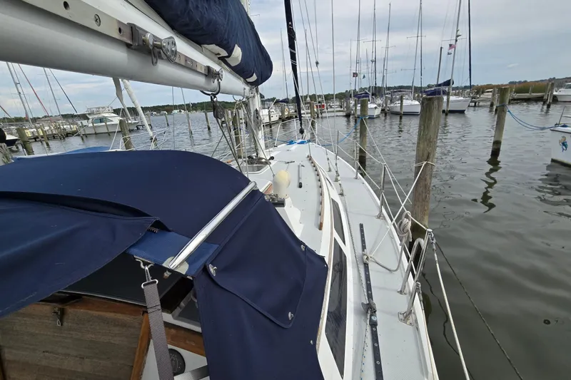 Slide: The Image of 1989 Catalina 36 sailboat docked at marina, featuring blue canvas cover and rigging. - 3
