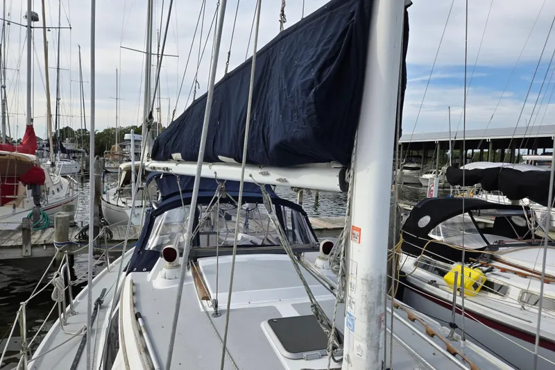 Slide: The Image of 1989 Catalina 36 sailboat docked at marina, featuring covered mainsail and rigging. - 32