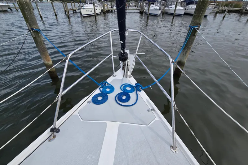 Slide: The Image of Bow of 1989 Catalina 36 sailboat docked, featuring coiled blue ropes and marina view. - 4