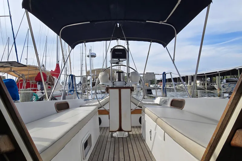 Slide: The Image of 1989 Catalina 36 sailboat cockpit with seating, steering wheel, and marina view. - 9