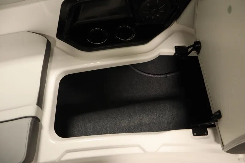 Slide: The Image of Interior storage compartment of 2026 Yamaha Boats AR250, featuring cup holders and speaker. - 15
