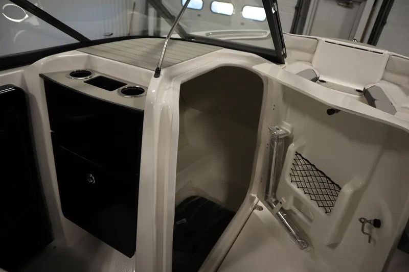 Slide: The Image of 2026 Yamaha Boats AR250 interior with storage compartment and cup holders. - 26