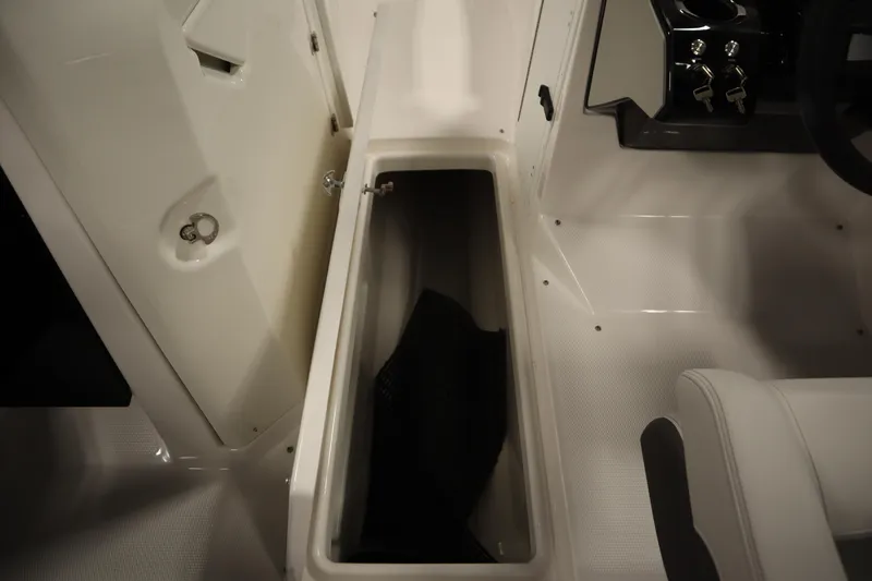 Slide: The Image of 2026 Yamaha Boats AR250 interior storage compartment with open hatch and seating area. - 28